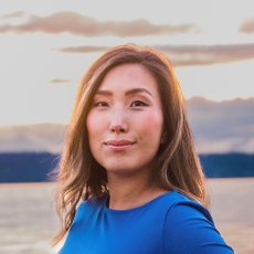 Photo of Jenny wearing a blue shirt with water in the background