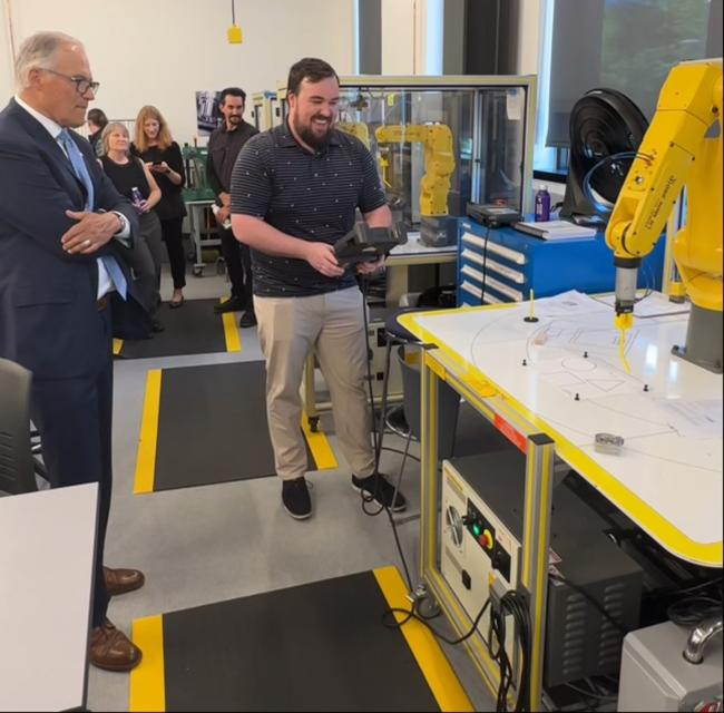 Gov. Jay Inslee observes a Shoreline Community College student demonstrating CNC milling.