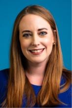 Headshot of Caitlin wearing a blue shirt