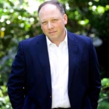 Photo of David wearing blue suit and white button-up shirt+